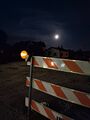 Barricade and full moon (7 August 2025) @ 10:06 p.m. Second Avenue East at Harvey Street, view to the south.