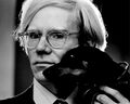 Andy Warhol poses for picture, allows viewer to work out the details.