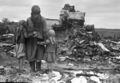 A woman and two girls look at their destroyed house (1943). See War (nonfiction).